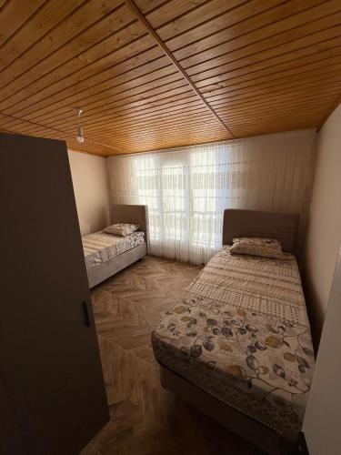 two beds in a room with a wooden ceiling at İlkay suit in Bandırma