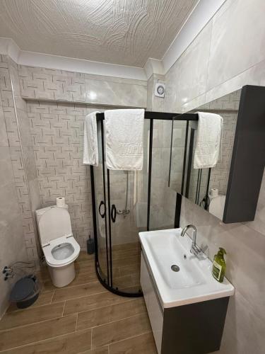 a white bathroom with a toilet and a sink at İlkay suit in Bandırma