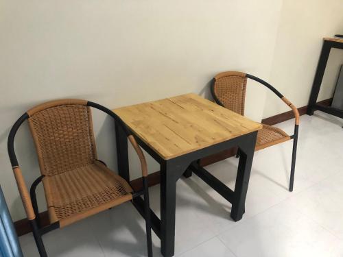a wooden table and two chairs sitting next to a table at Amantra Resort Satun in Ban Prok To Lem