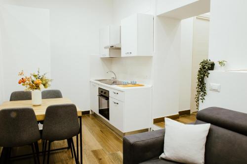 un soggiorno con un tavolo e una cucina di Chiaia Exclusive Apartment a Napoli