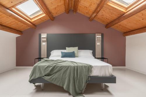 a bedroom with a large bed in a room with wooden ceilings at La Terrazza su Dante Rooms in Palermo