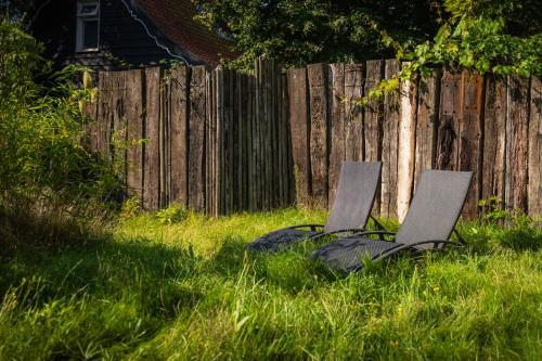 two chairs in the grass next to a fence at TUUS in Dishoek in Dishoek