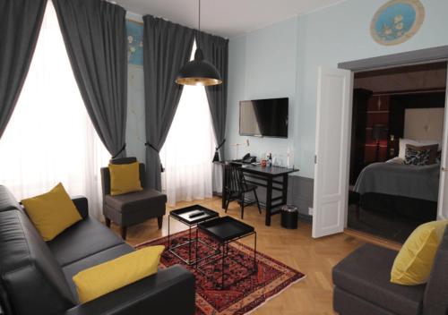 a living room with a couch and a table and a bed at Clarion Hotel Wisby in Visby