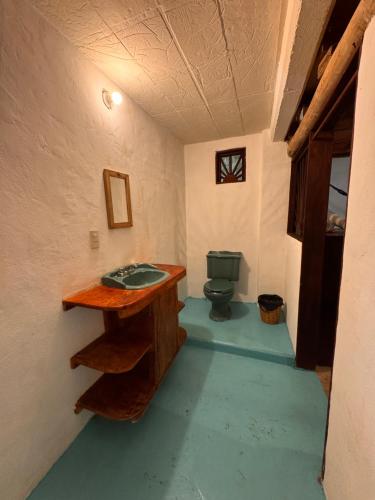 a bathroom with a green toilet in a room at Lo Cósmico in Zipolite