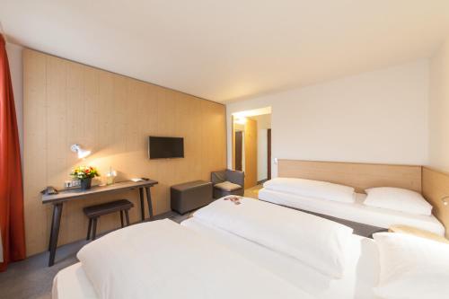 a hotel room with two beds and a desk at Sure Hotel by Best Western Muenchen Hauptbahnhof in Munich