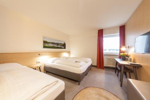 a hotel room with two beds and a television at Sure Hotel by Best Western Muenchen Hauptbahnhof in Munich