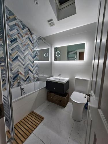 a bathroom with a tub and a toilet and a sink at Little Cottage Oassis in Dublin
