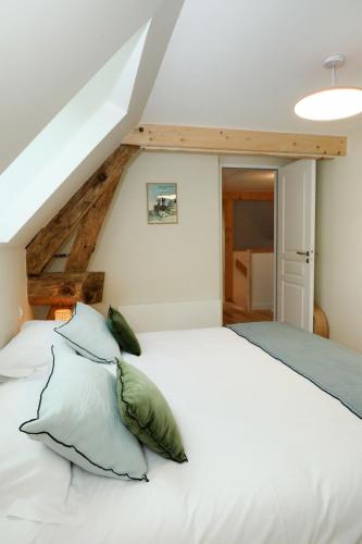 - une chambre avec un lit blanc et des oreillers verts dans l'établissement Le Jardin d'Aimee by La boite en Plus, à Villers-Saint-Frambourg