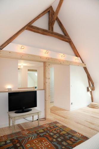 un salon avec une télévision à écran plat dans un loft dans l'établissement Le Jardin d'Aimee by La boite en Plus, à Villers-Saint-Frambourg