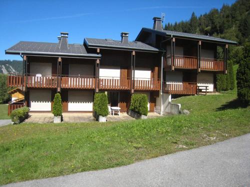 une grande maison avec une terrasse sur une pelouse dans l'établissement Charmant studio avec terrasse et WIFI à La Clusaz - FR-1-459-64, à La Clusaz