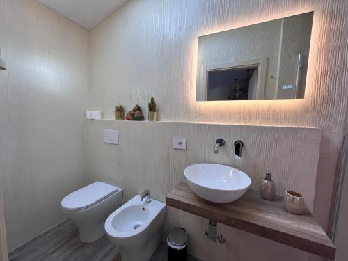a bathroom with a sink and a toilet and a mirror at Camere e attico al mare in Gabicce Mare