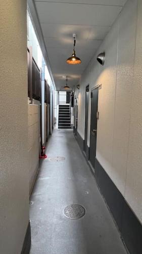 an empty hallway of a building with a hallway at Osaka Umeda West JR Tsukamoto Inn BB in Osaka