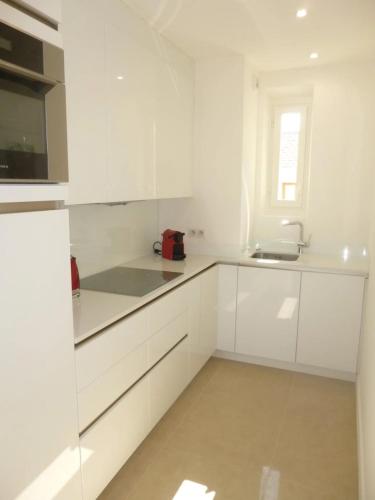 une cuisine blanche avec des armoires blanches et un évier dans l'établissement REF 990 - Cannes Center - Apartment for rent, à Cannes