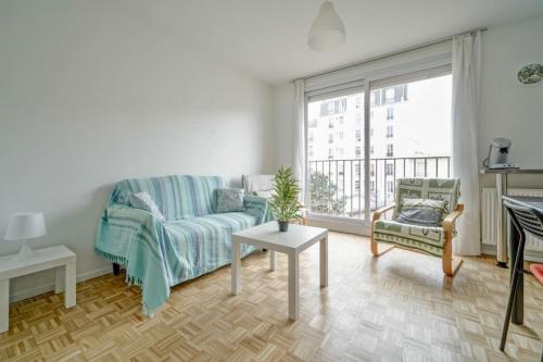 un salon avec un canapé et une fenêtre dans l'établissement Bright apartment close to tourist attractions, à Saint-Ouen