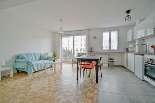 une cuisine et un salon avec une table et un canapé dans l'établissement Bright apartment close to tourist attractions, à Saint-Ouen