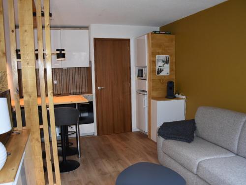 un petit salon avec un canapé et une cuisine dans l'établissement Appartement cosy avec piscine chauffée et terrasse sud à Pralognan-la-Vanoise - FR-1-464-118, à Pralognan-la-Vanoise