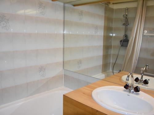 une salle de bain avec un lavabo et une baignoire dans l'établissement Appartement cosy avec piscine chauffée et terrasse sud à Pralognan-la-Vanoise - FR-1-464-118, à Pralognan-la-Vanoise