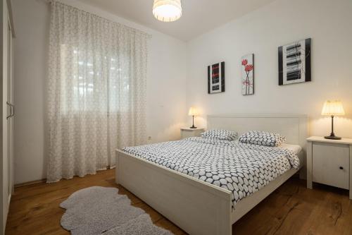 Un dormitorio blanco con una cama y una ventana. en Villa Mirkov San, en Pakovo Selo