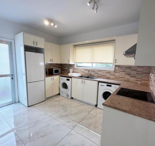 a kitchen with a white refrigerator and a dishwasher at Melia Suites in Limassol