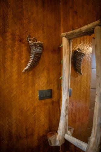 a mirror on a wall withanimal horns on it at Ela Forest Stay in Kannādi