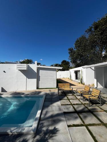 a patio with benches and a swimming pool at Summerdays Studios in Coteau Raffin