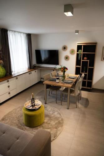 a living room with a table and a dining room at LA Poivriere in Durbuy nieuw appartement met gemeenschappelijke jacuzzi en sauna in Durbuy
