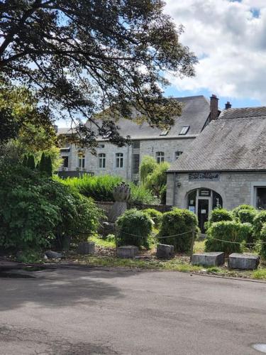 a large white house with a tree in front of it at LA Poivriere in Durbuy nieuw appartement met gemeenschappelijke jacuzzi en sauna in Durbuy