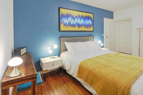 une chambre avec un lit et un mur bleu dans l'établissement Nouveau - Jolie Pépite Le Rabelais, à Nantes
