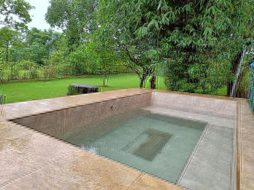 a swimming pool in the middle of a yard at Sharanya - the Sanctuary in Jambhulpāda