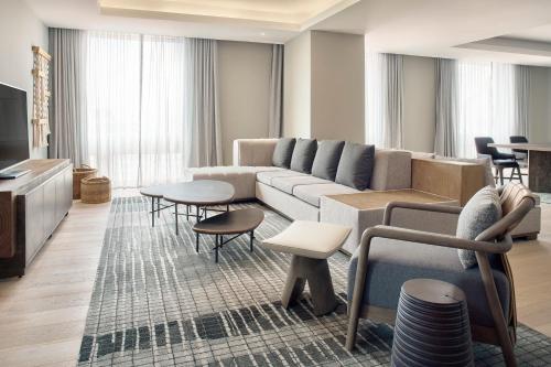 a living room with a couch and tables and chairs at JW Marriott Hotel Mexico City Polanco in Mexico City