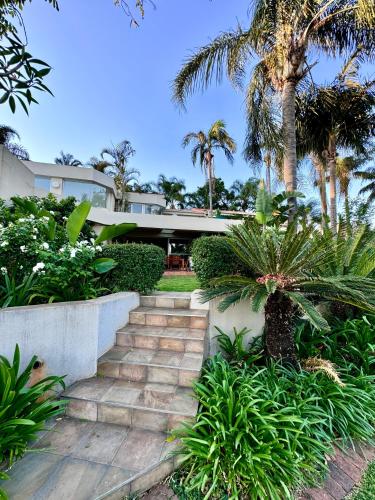 a staircase leading to a house with palm trees at Olives by Agnes in Hartbeespoort