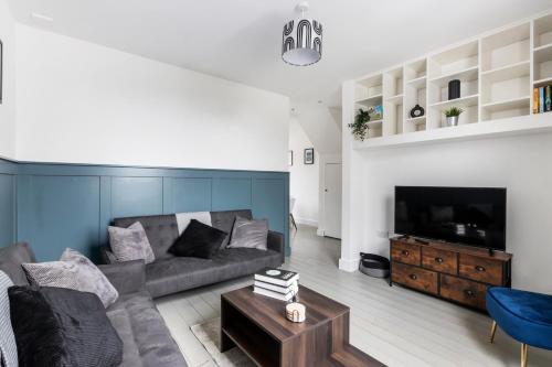 a living room with a couch and a tv at St Albans Centre Home - 4BR - 2 FREE parking in St. Albans