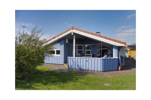 a blue house with a red roof at Ferienhaus Ty Glaz in Wesselburenerkoog