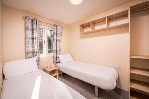 a bedroom with two beds and a window at St. Ives Holiday Village in St Ives