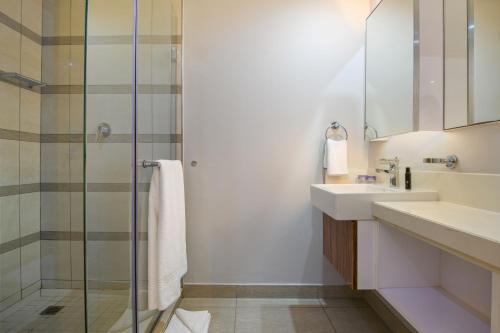 a bathroom with a sink and a shower at The Capital Pearls Hotel in Durban