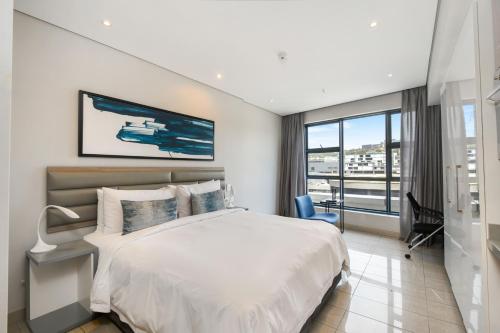a bedroom with a large bed and a large window at The Capital Pearls Hotel in Durban