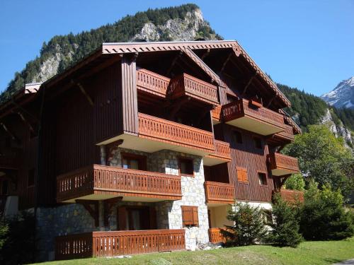 un grand bâtiment avec des balcons en bois sur une montagne dans l'établissement Charmant Duplex Mezzanine avec Balcon près des Pistes, Pralognan-la-Vanoise - FR-1-464-43, à Pralognan-la-Vanoise