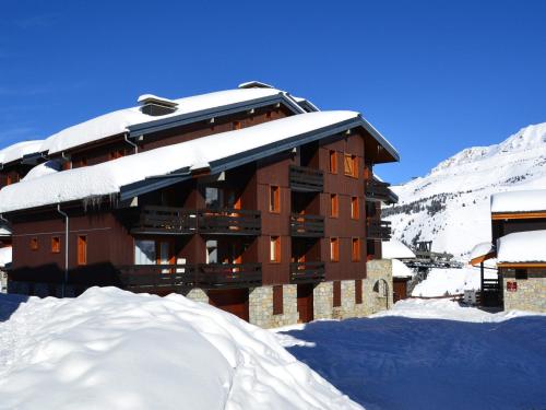 un bâtiment recouvert de neige avec un tas de neige dans l'établissement Studio 3* pour 4 pers. avec balcon, skis aux pieds, proche commerces et remontées mécaniques - FR-1-182-193, à Les Allues