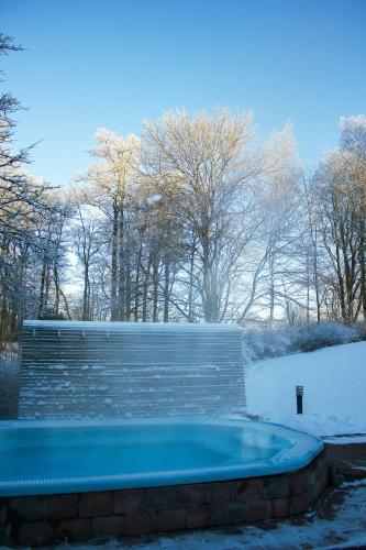 aenced in hot tub in a snow covered yard at Ronnums Herrgård in Vargön