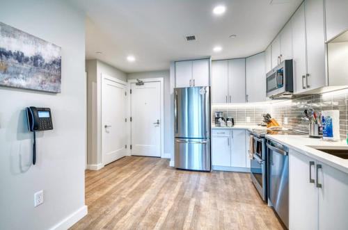 a kitchen with white cabinets and a stainless steel refrigerator at Luxury Apt Near Downtown in Quincy