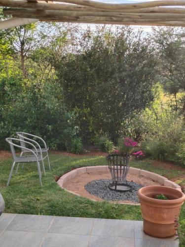 a patio with a chair and a fire pit at Sani Pass View Cottage in Himeville