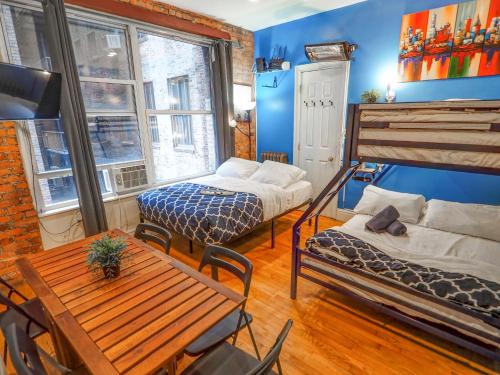 a room with two beds and a table in it at Metropolitan Studio Apartments Manhattan in New York