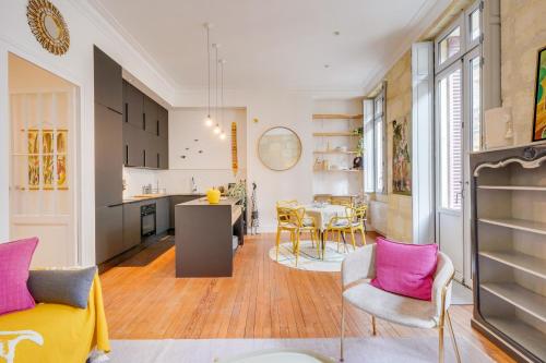 une cuisine et un salon avec des chaises roses et grises dans l'établissement MDOR - La Fée Girafe, à Bordeaux