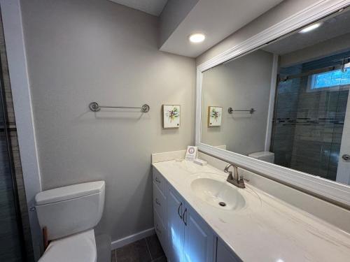 a bathroom with a toilet and a sink and a mirror at Hideaway in Southport