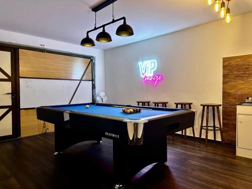 a pool table in a room with a neon sign at Stilvolle Wellness-Ferienwohnung in Neef Whirlpool, Sauna, Grill, Fitness, Billard & Moselblick in Neef