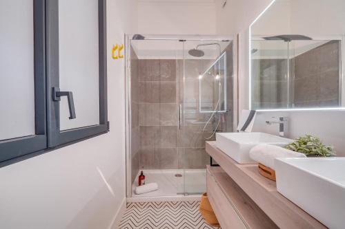 une salle de bain blanche avec un lavabo et une douche dans l'établissement MDOR - La Fée Girafe, à Bordeaux