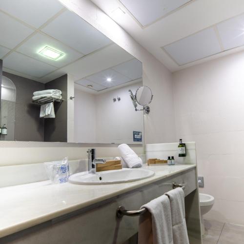 a bathroom with a sink and a large mirror at Pato Amarillo in Punta Umbría