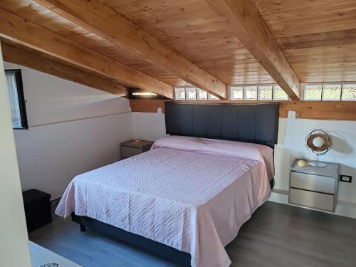 a bedroom with a large bed in a room with wooden ceilings at New house in Qualiano