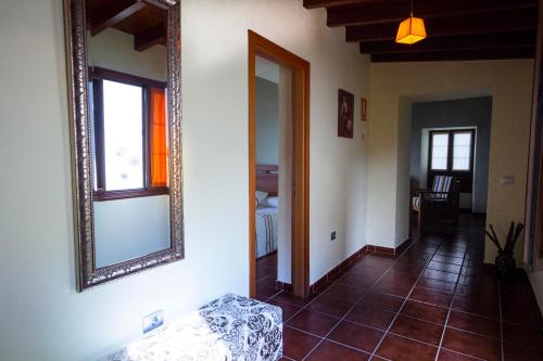 een woonkamer met een spiegel aan de muur bij Casa Rural Los Perales in Mocanal