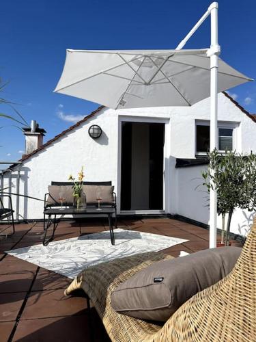 a patio with a table and an umbrella at Über den Dächern der Landshuter Altstadt in Landshut